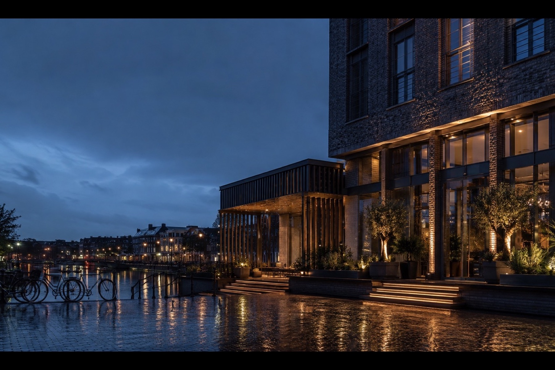 Gebouw aan het water in Utrecht bij blauw uur, licht weerspiegeld in de gracht